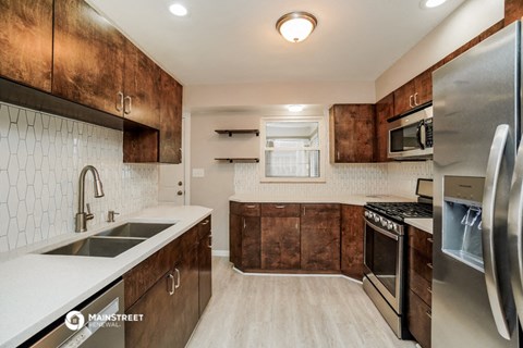 a modern kitchen with stainless steel appliances and wooden cabinets