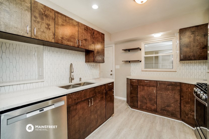 a white kitchen with wooden cabinets and a sink