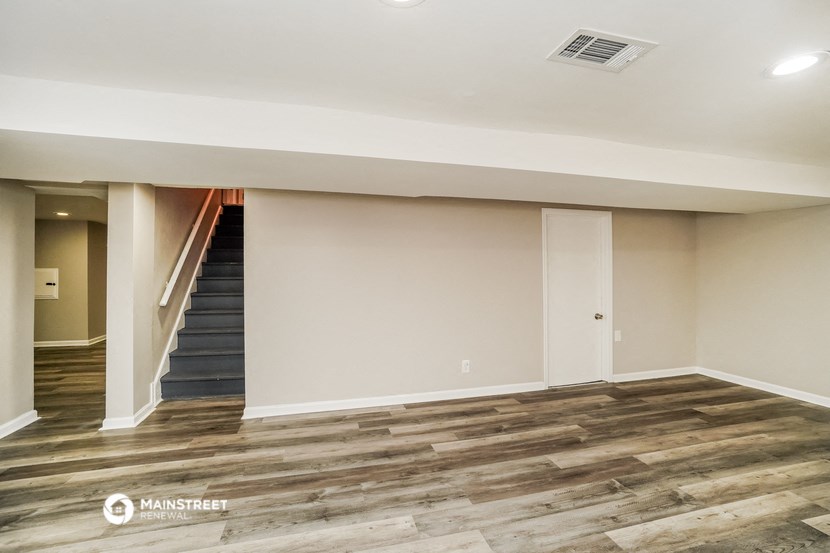 a empty living room with wood flooring and a staircase