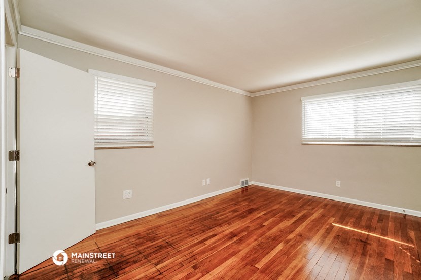 the living room of a home with wood flooring and a door