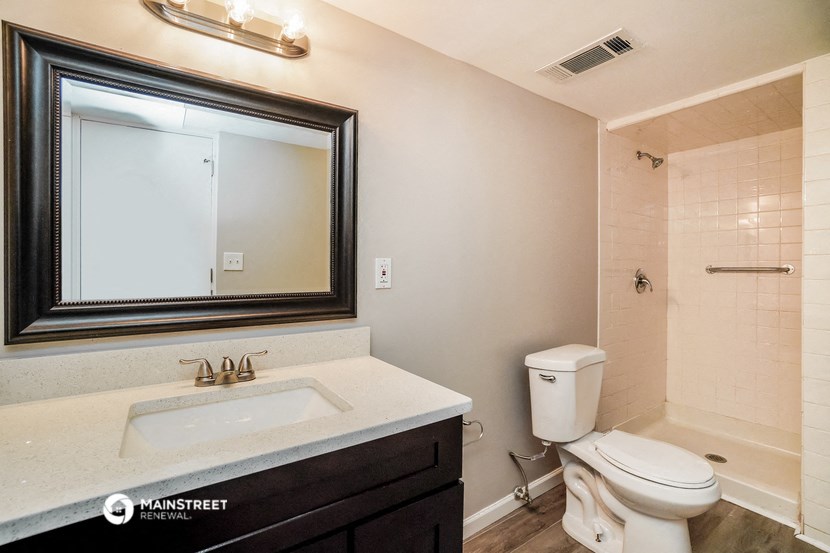 a bathroom with a sink toilet and a mirror