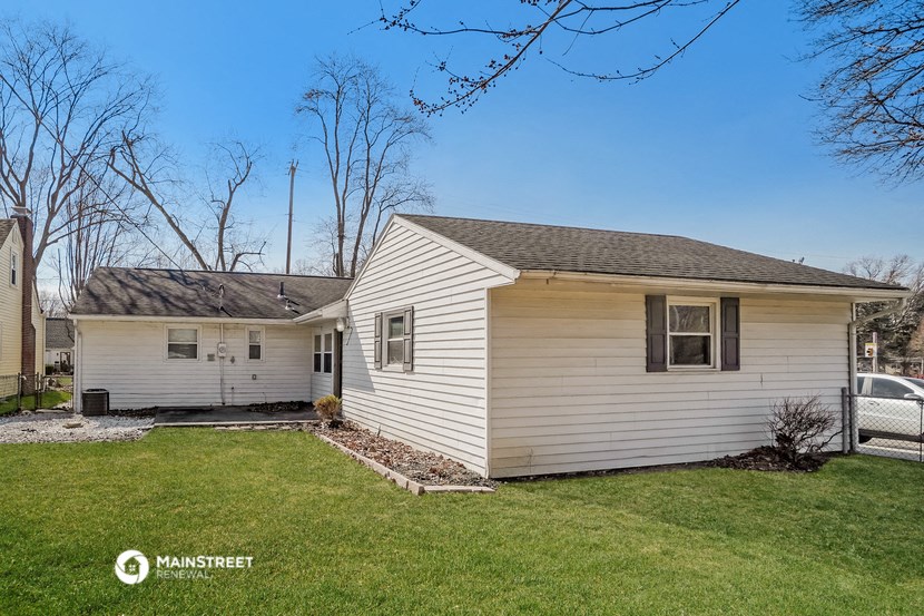 a white house with a yard and a car in the driveway