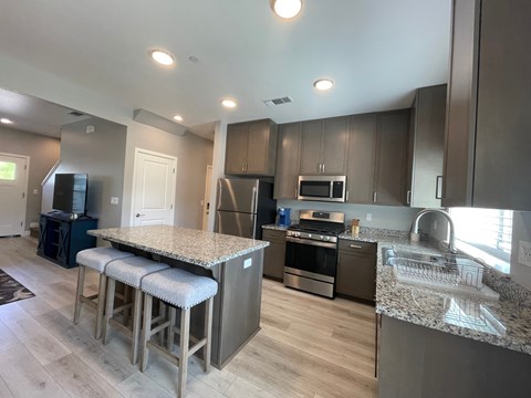 A kitchen with a granite countertop and stainless steel appliances.