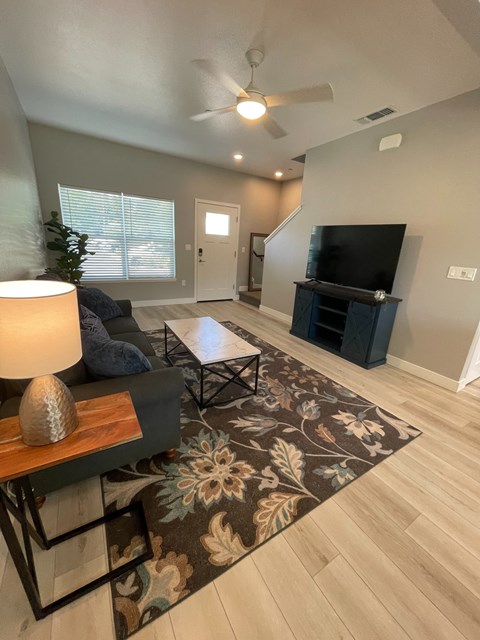 A living room with a couch, a coffee table, and a television.