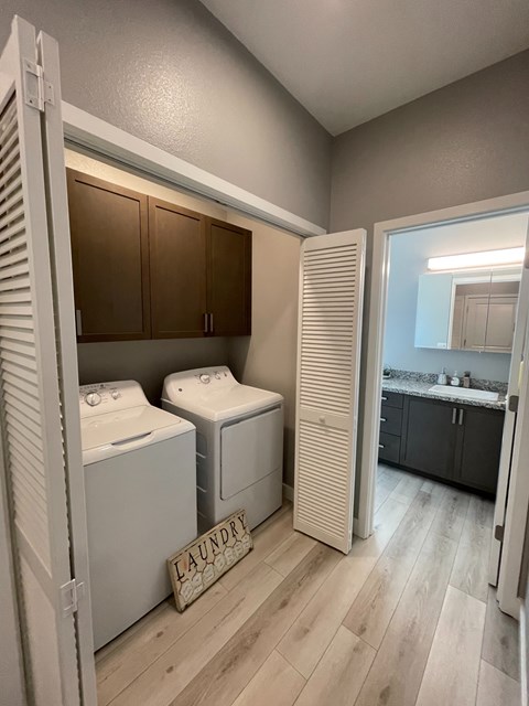A laundry sign is on the floor next to a washer and dryer.