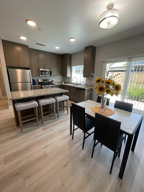 A kitchen with a table and chairs in the foreground.