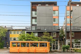 a streetcar is parked in front of an apartment building