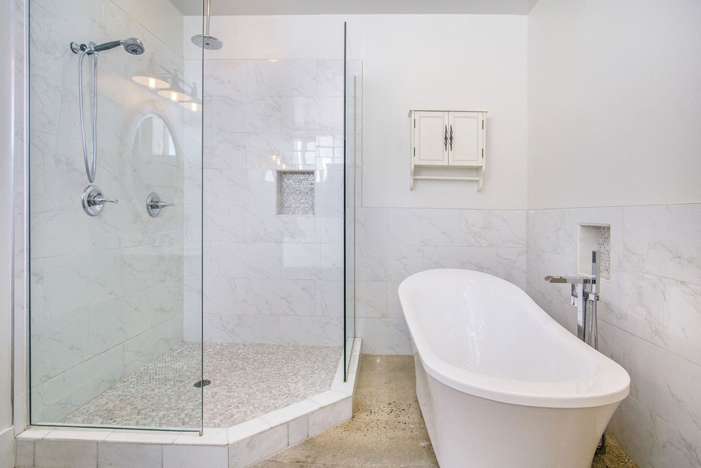 a white bathroom with a tub and a shower
