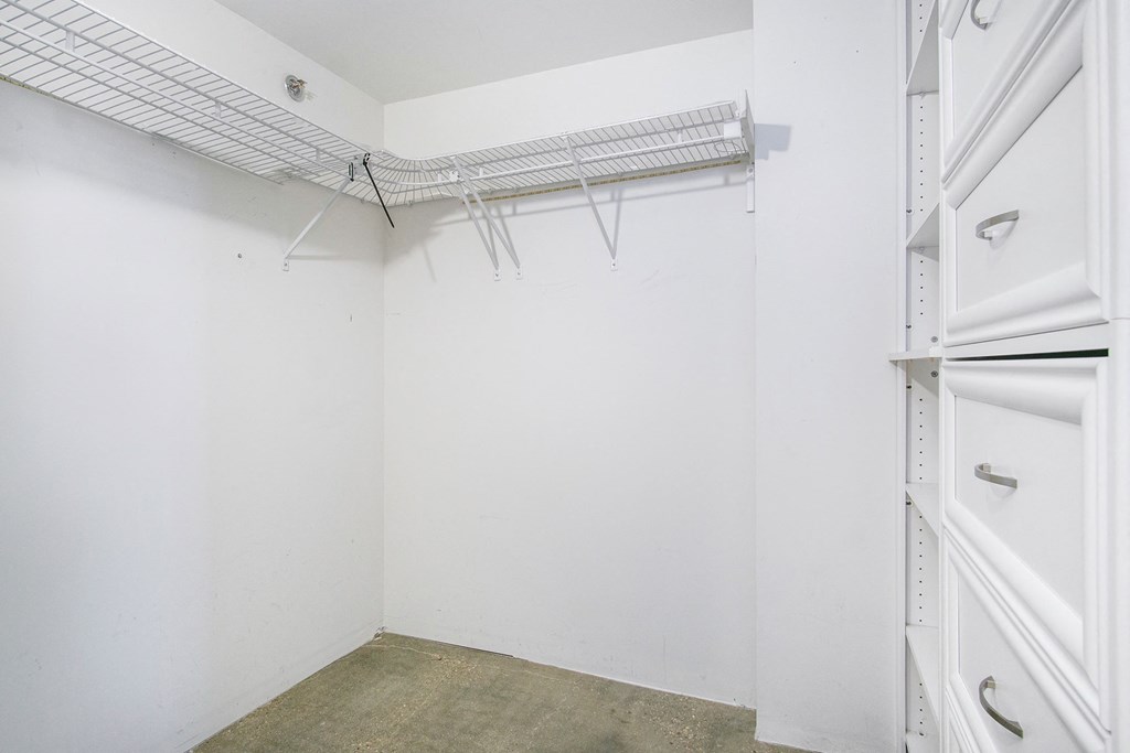 an empty room with a white wall and a closet with white doors