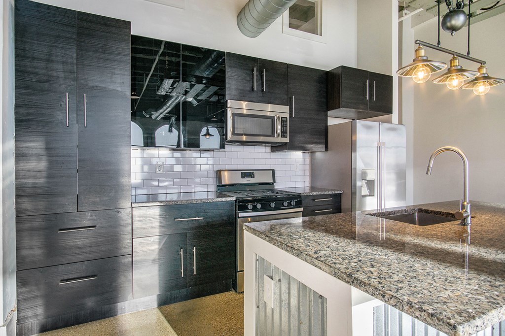 a kitchen with black cabinets and a granite counter top