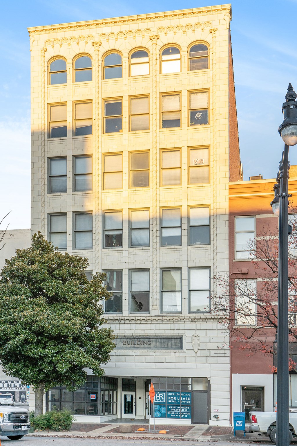 a tall building with a tree in front of it on a city street