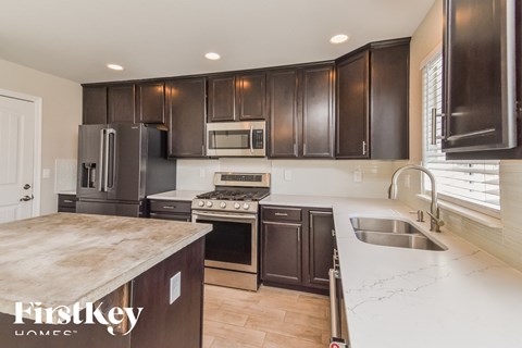 A kitchen with dark brown cabinets and stainless steel appliances.