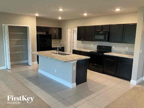 a kitchen with black cabinets and a counter top