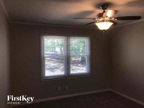 a bedroom with a ceiling fan and a window