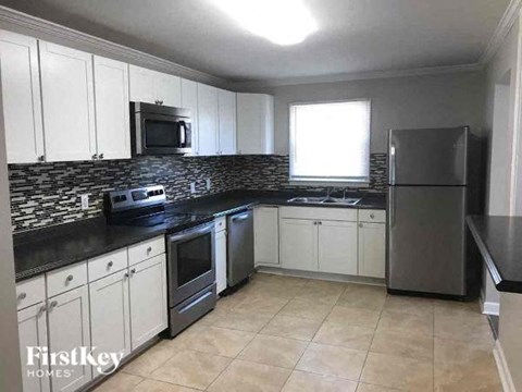 a kitchen with white cabinets and stainless steel appliances