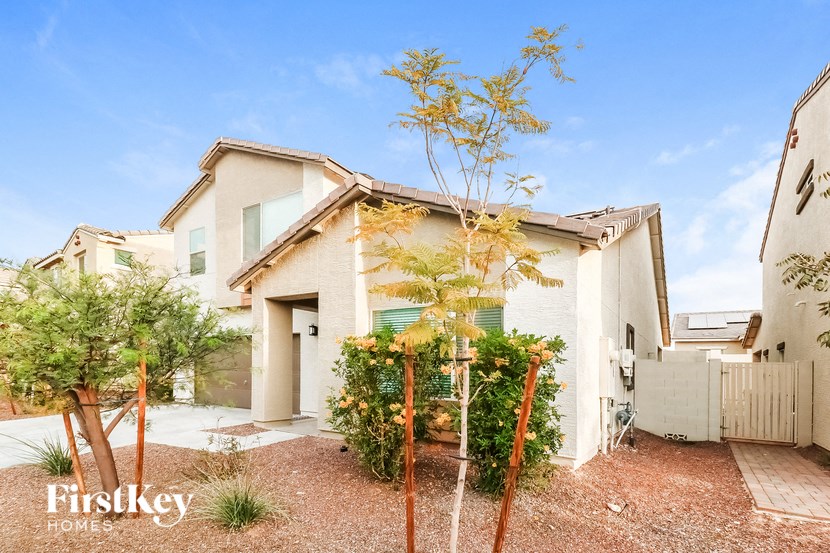 a small white house with a yard and trees