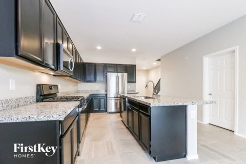 a modern kitchen with black cabinets and granite counter tops