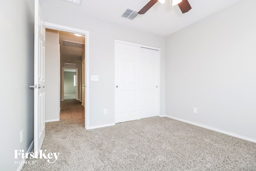 a bedroom with a white door and a ceiling fan