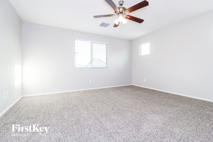 an empty room with a ceiling fan and a window