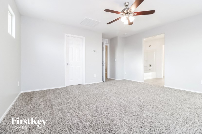 an empty living room with a ceiling fan