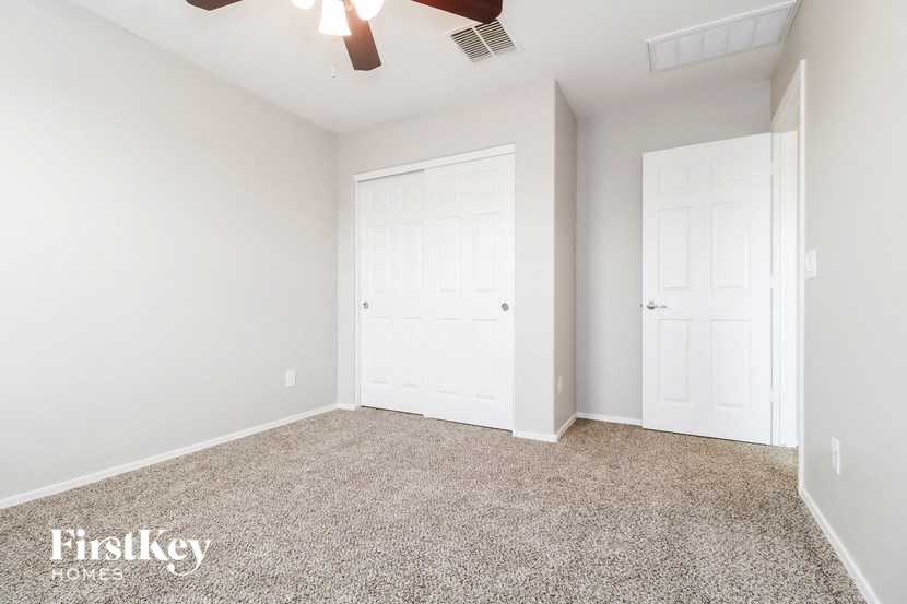 a bedroom with two white doors and a carpeted floor