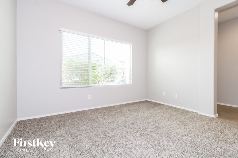 an empty room with a window and carpet