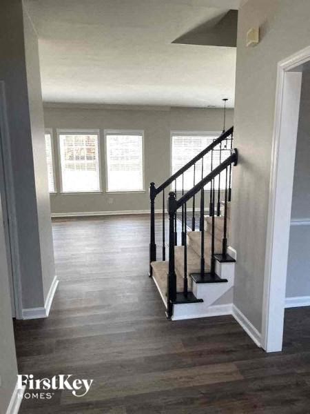 a living room with a staircase and a hard wood floor
