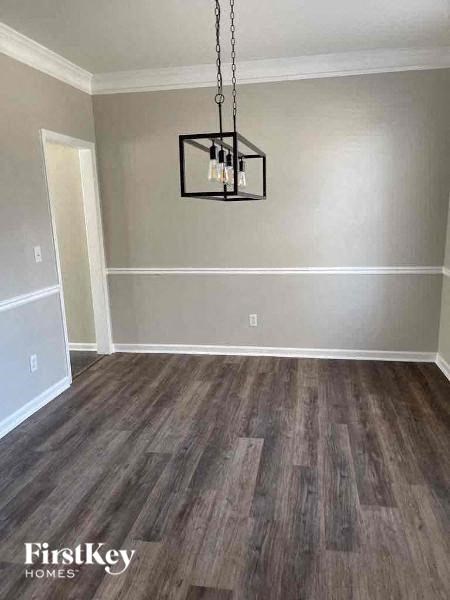 a empty living room with wood floors and a chandelier
