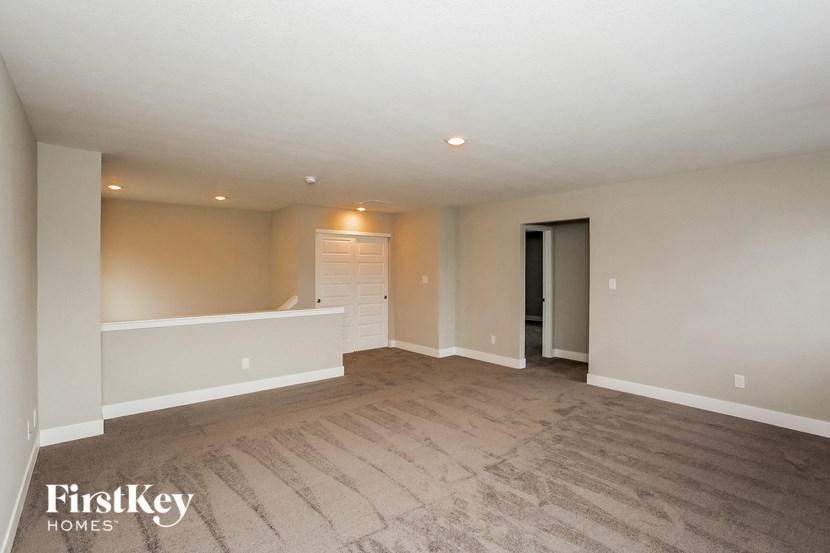 an empty living room with a white floor and a white door