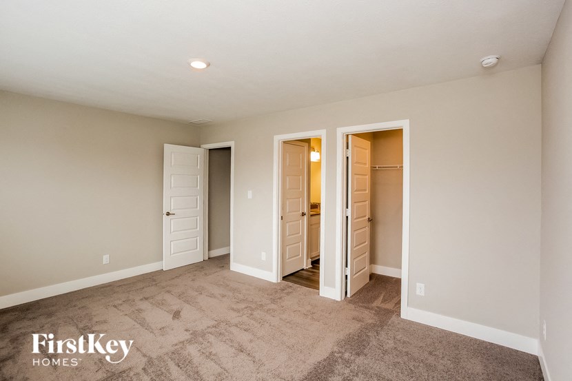 a master bedroom with closets and a carpeted floor