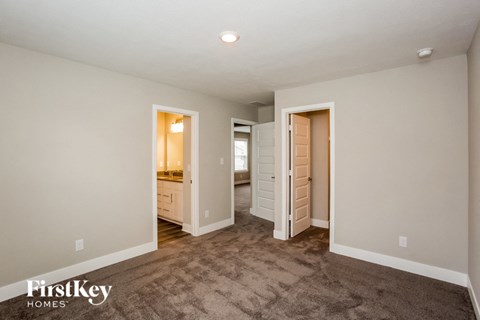 a living room with carpet and a door to a bathroom