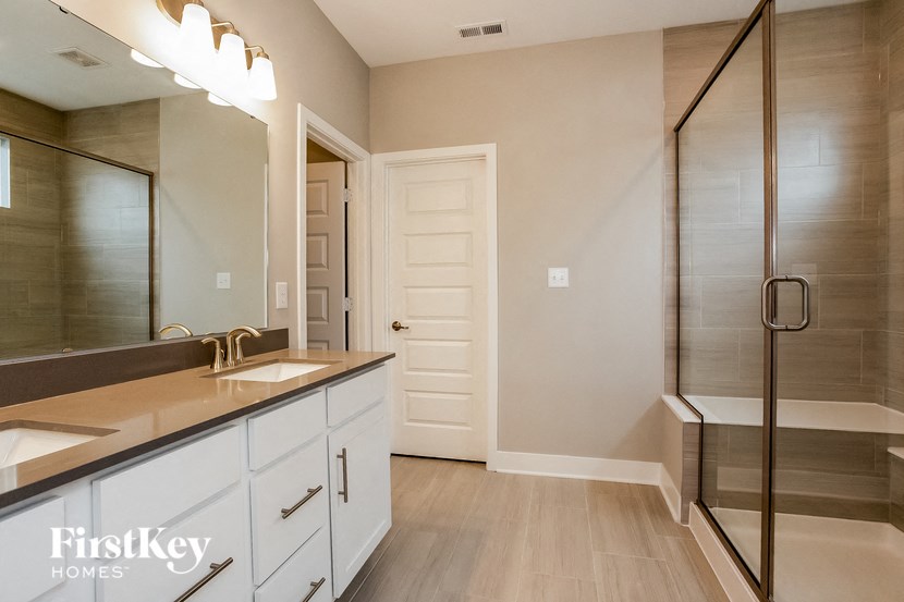 a bathroom with a shower and a sink and a mirror