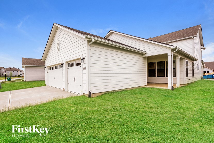 a white house with a garage and a grass yard