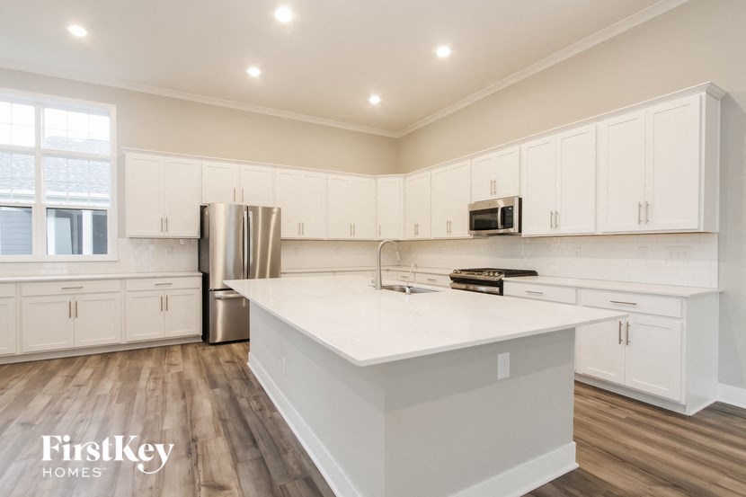 a large kitchen with white cabinets and a white counter top