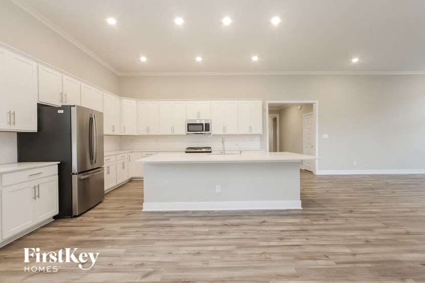 an empty kitchen with white cabinets and a white counter top