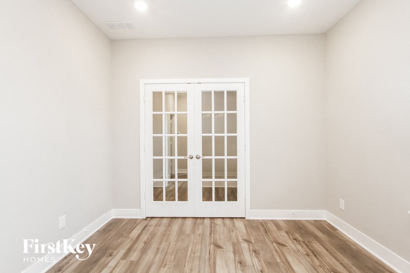 a white room with a door and a wooden floor