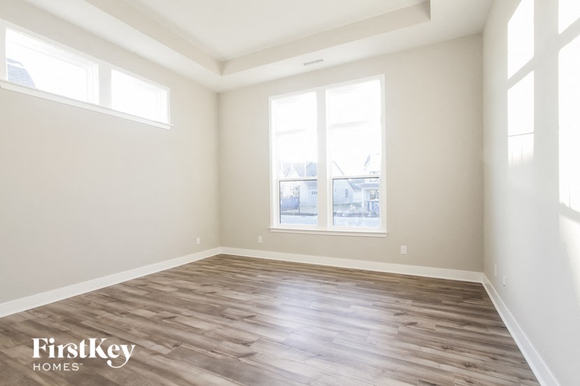 an empty living room with wood floors and a window