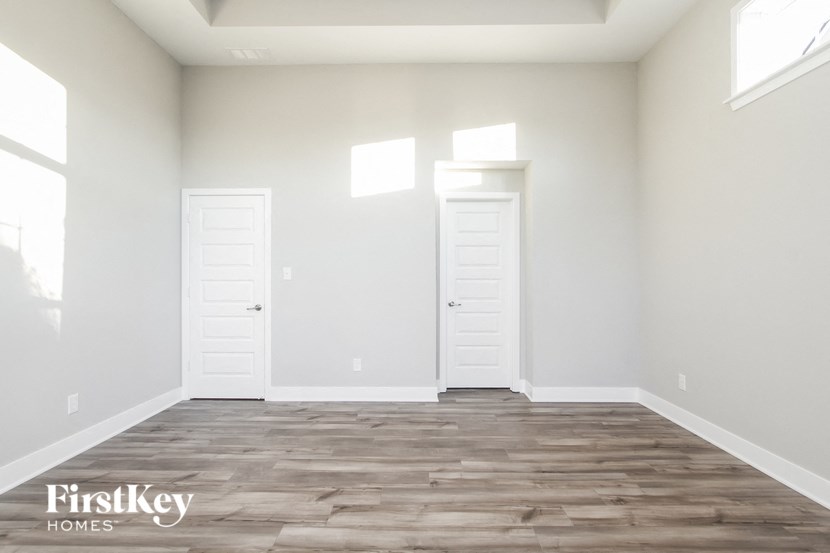 an empty living room with white walls and wood flooring