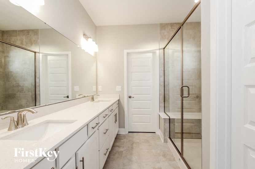 a bathroom with a large mirror and a sink and a shower