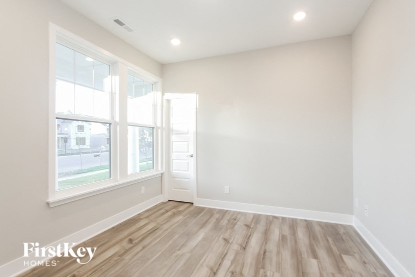an empty room with wood flooring and a window