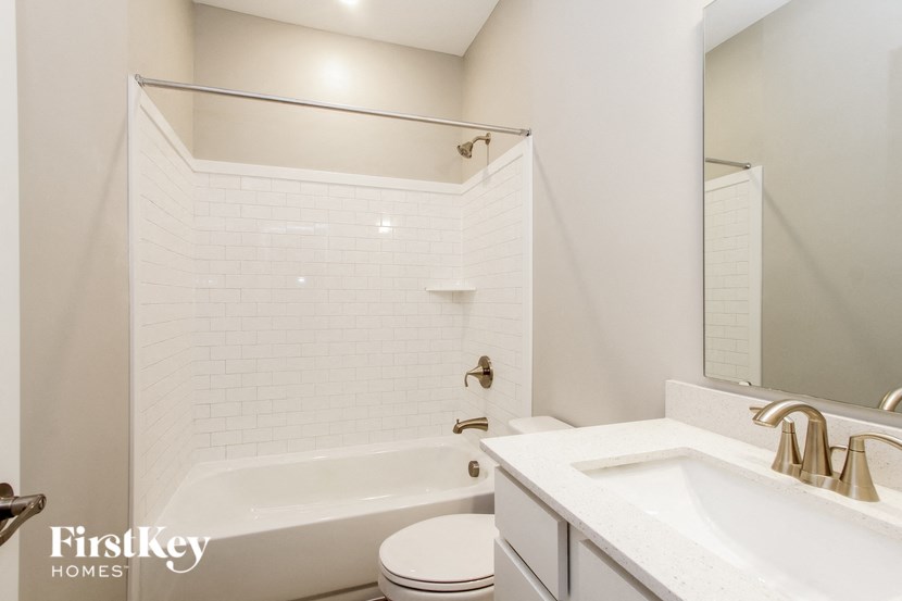 a white bathroom with a tub and a sink and a toilet
