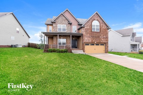 a house with a yellow garage door in front of a lawn