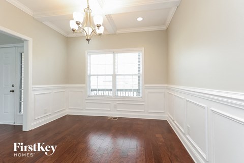 a dining room with white walls and a window