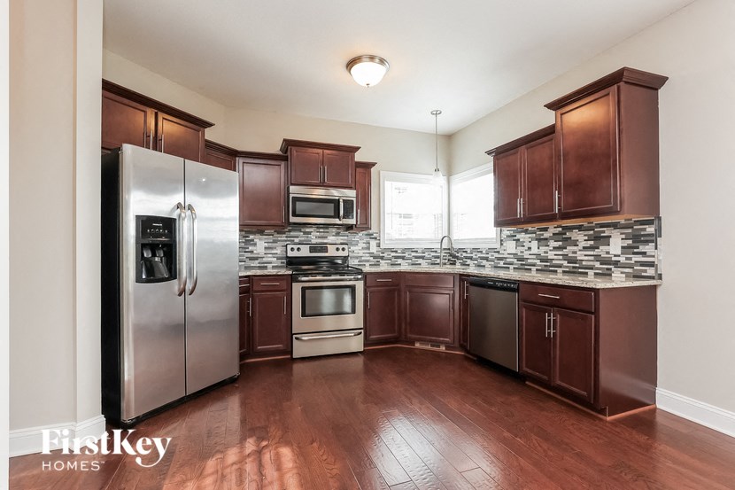 a kitchen with dark wood cabinets and stainless steel appliances