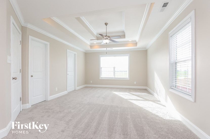 an empty living room with a ceiling fan and a window