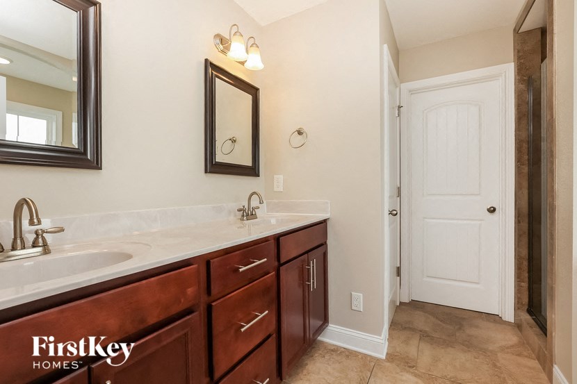 a bathroom with a sink and a mirror and a door