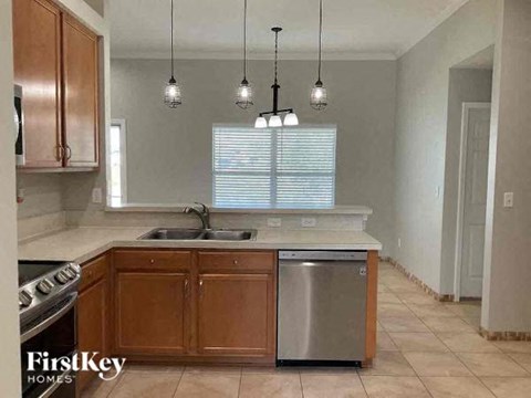 A kitchen with wooden cabinets and a stainless steel dishwasher.