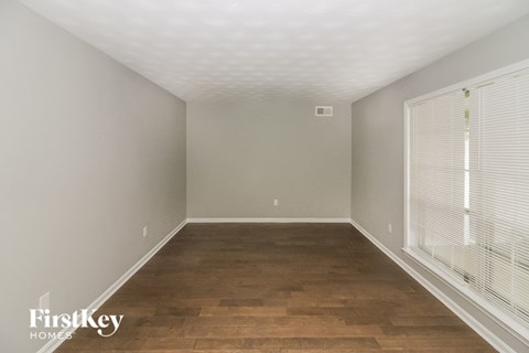 a bedroom with wood flooring and a large window