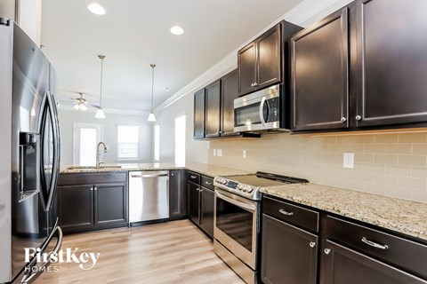 A modern kitchen with dark brown cabinets and stainless steel appliances.