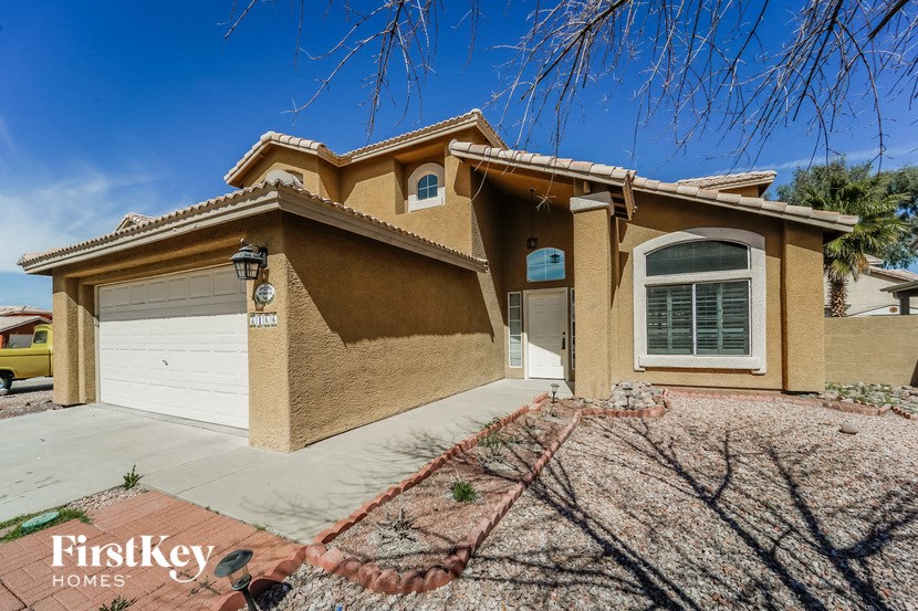 A house with a brown facade and a white garage door is for sale.